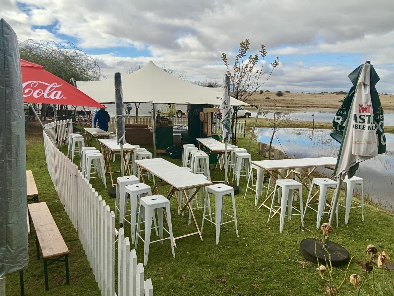 Castle Corner branded bar with white picket fencing at an outdoor festival