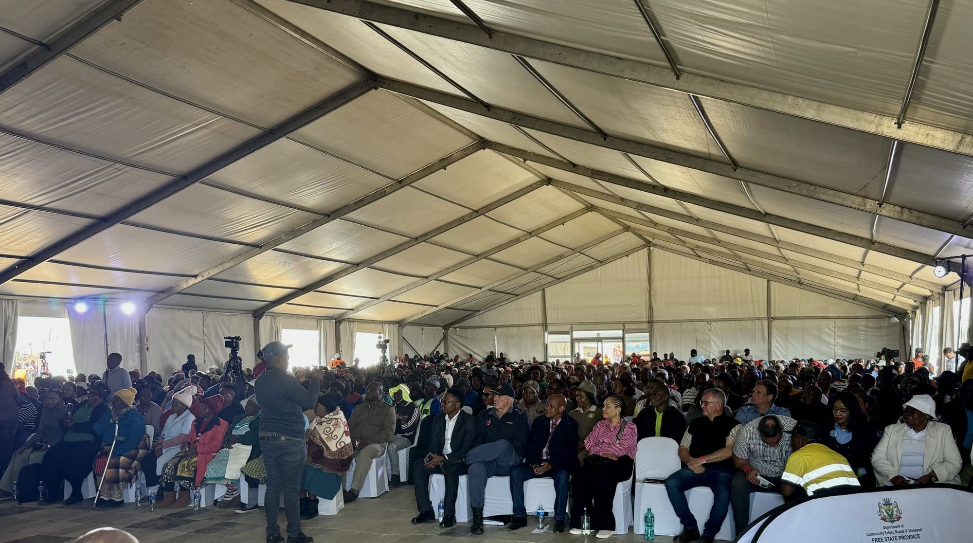 Packed audience inside a large frame marquee