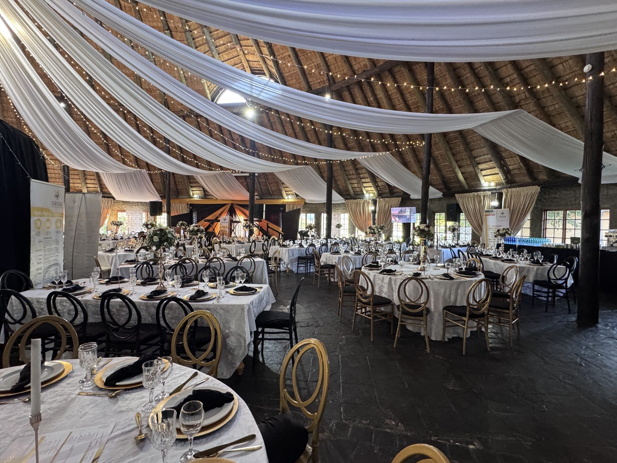 Gala dinner venue with draped ceiling and black, white and gold styling