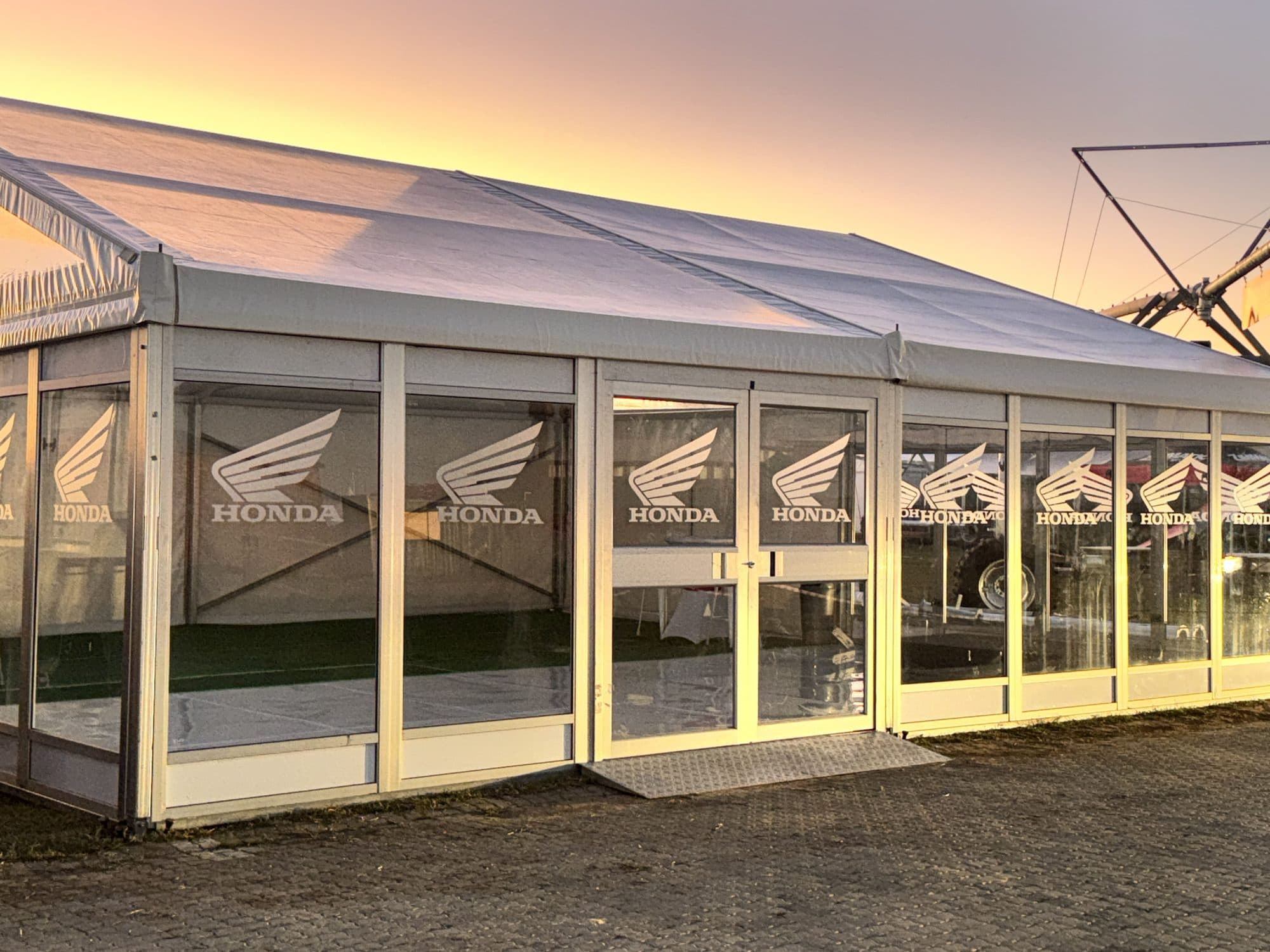 Honda branded glass pavilion at sunset on an expo site