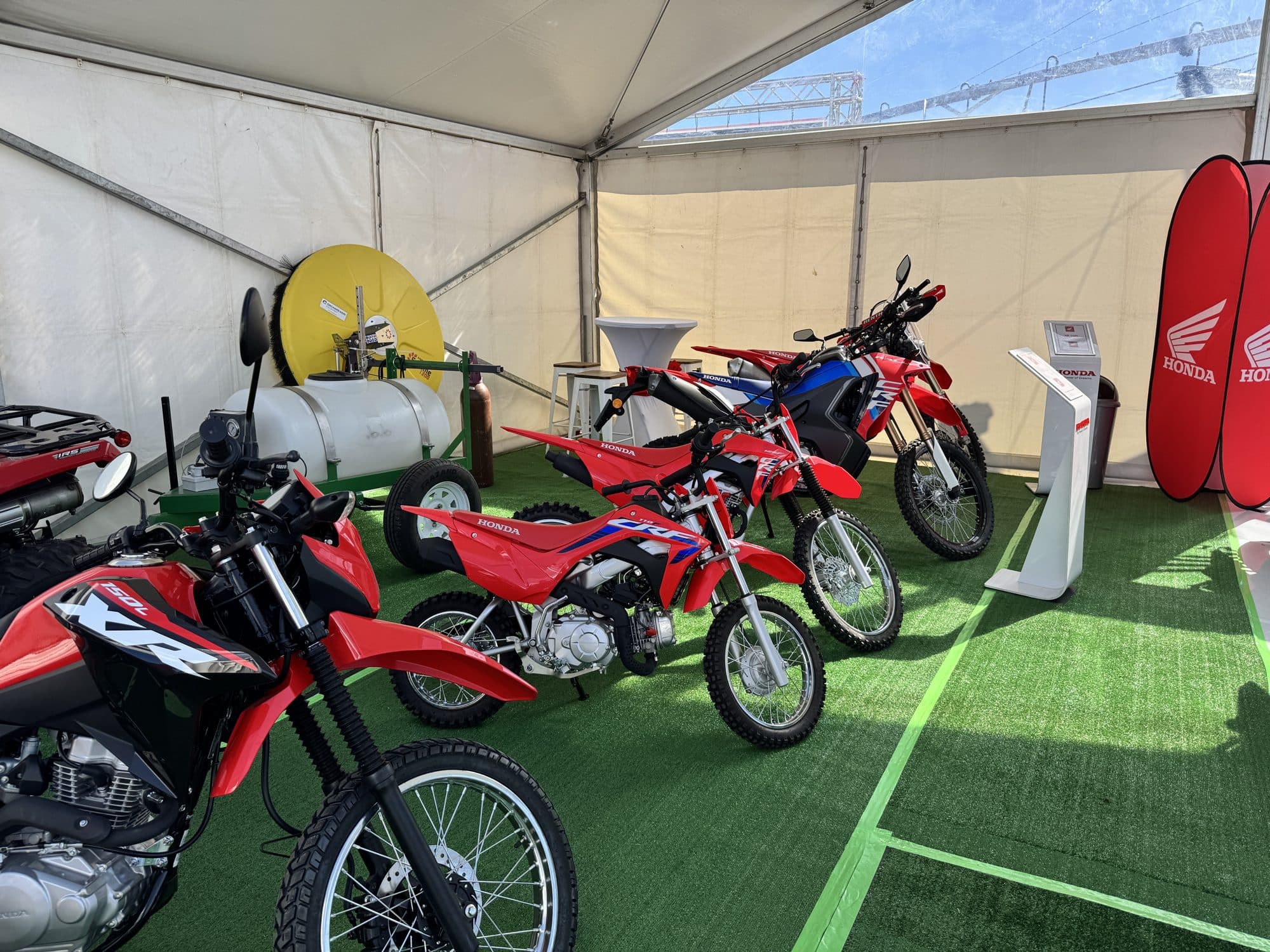 Honda motorcycles displayed inside a glass-walled expo pavilion