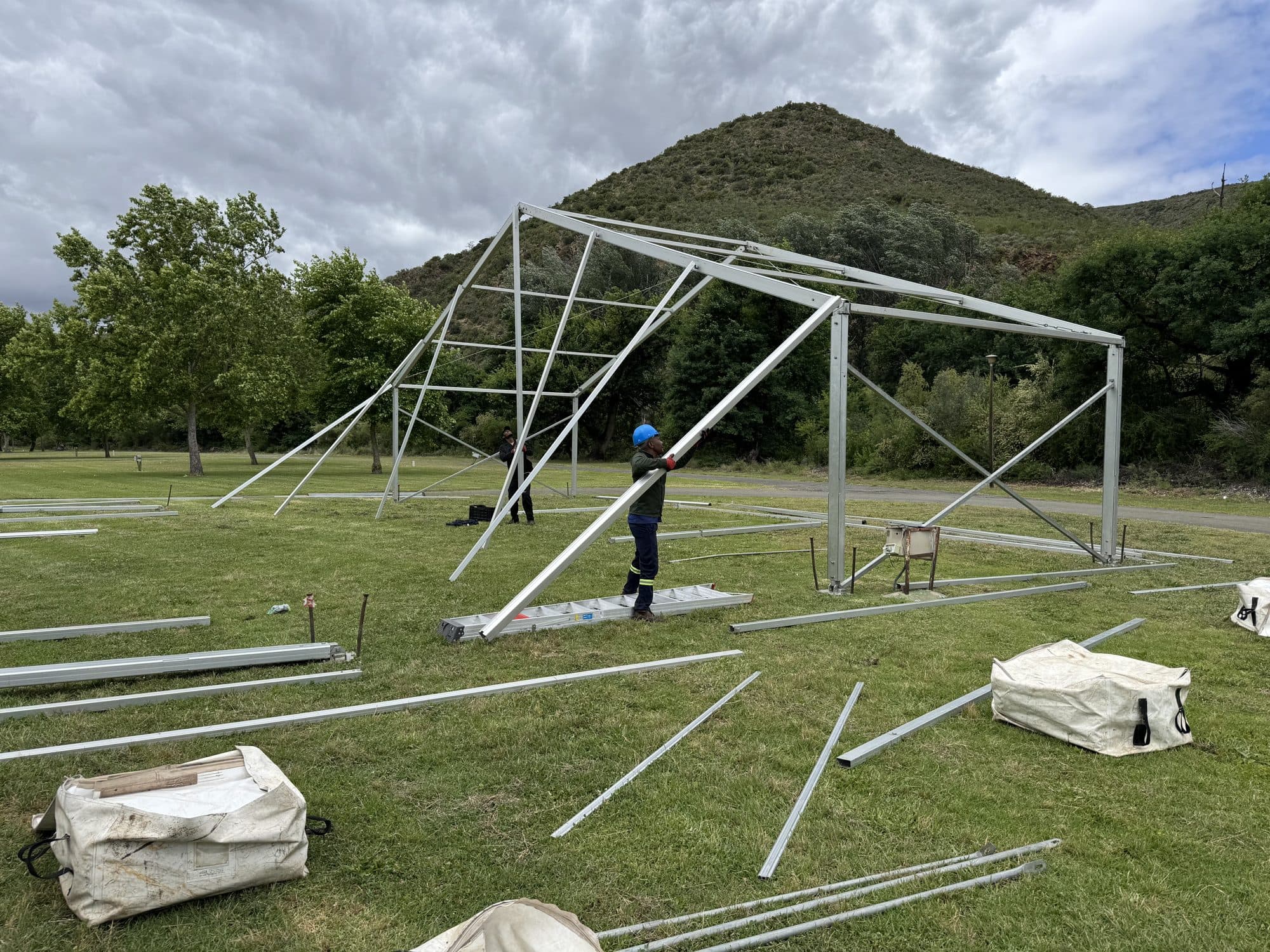 Marquee frame being erected against a mountain backdrop