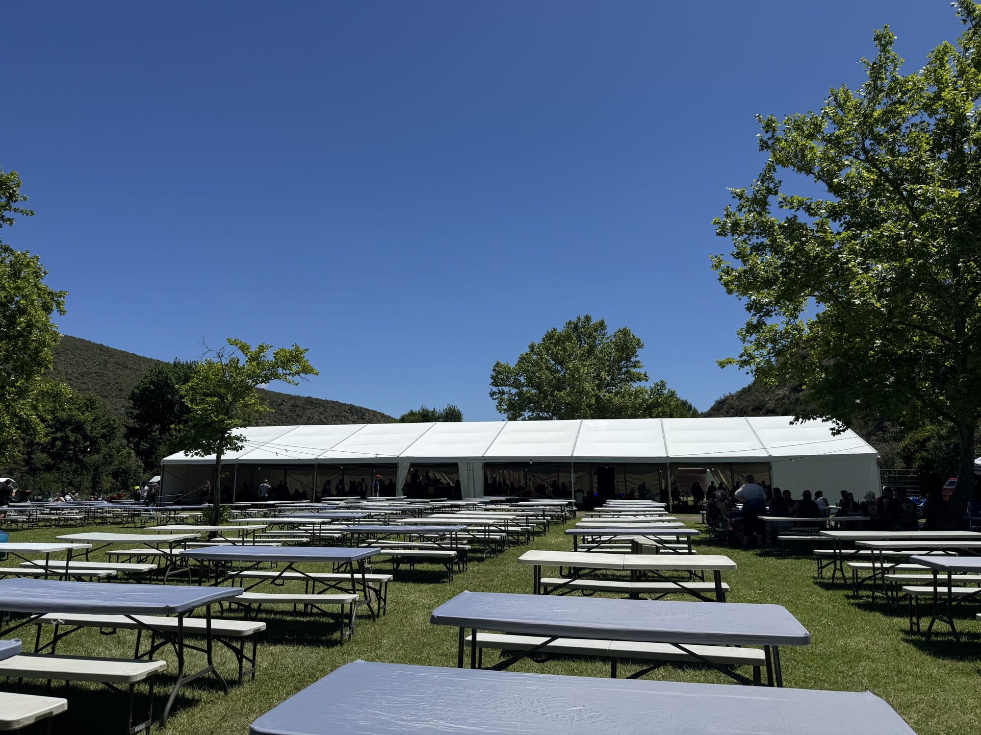 Long benching and marquee at an outdoor rally venue